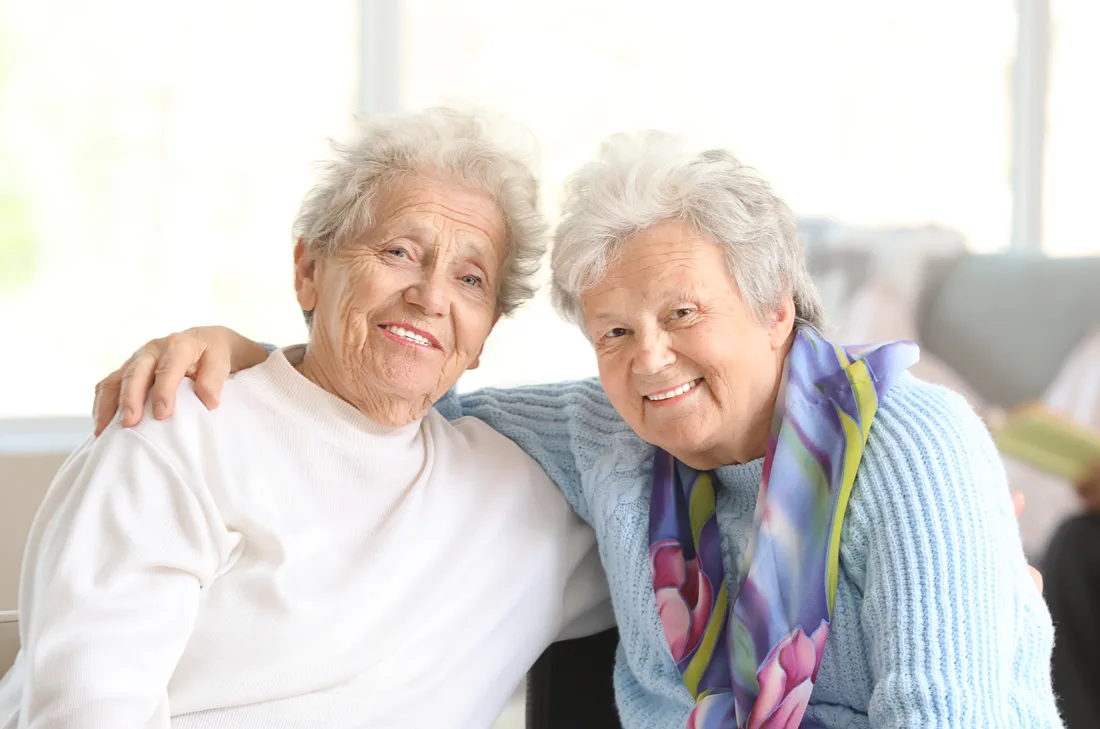two-senior-women-smile-on-couch