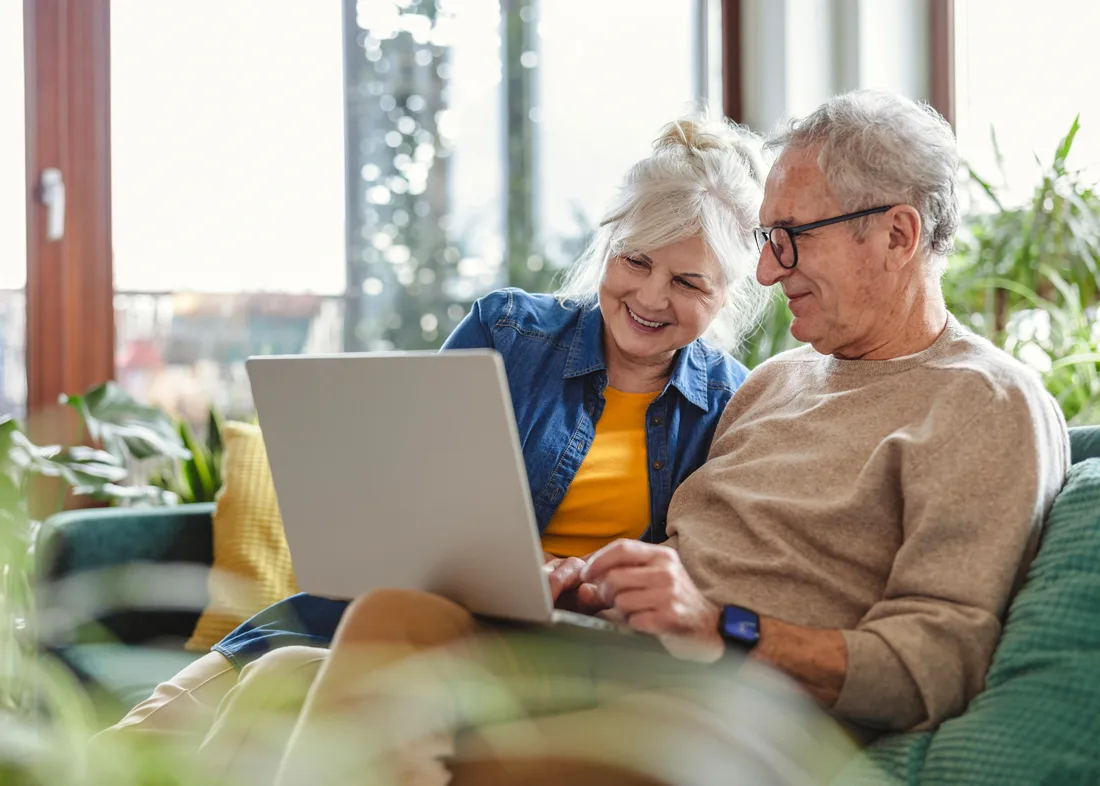 happy-senior-couple-on-couch Older adults playing a game with a caregiver